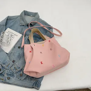Pink canvas tote bag with colorful letter embroidery and dual straps for daily commuting