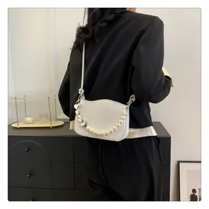 Détail du petit sac blanc matelassé avec poignée en perles et cœur en métal
