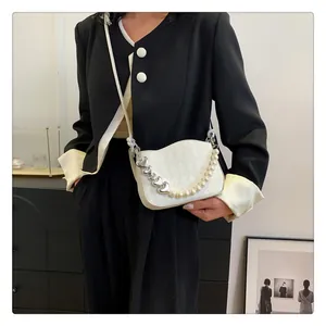 Détail du sac à bandoulière matelassé avec poignée en métal en forme de cœur et perles