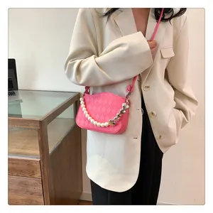 Détail du sac bandoulière matelassé rose avec perles et chaîne en forme de cœur
