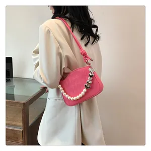 Détail du sac matelassé rose avec bandoulière en perles et breloques en cœur