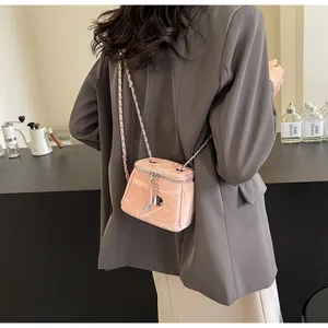 Détail d'un mini sac seau rose avec pendentif floral en forme de camélia argenté