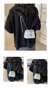 Détail du sac seau argenté avec texture froissée et pendentif fleur décoratif