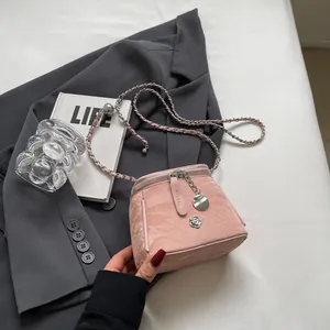 Sac seau plissé rose avec breloque fleurie argentée et bandoulière en chaîne