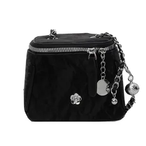 Mini sac seau noir chic avec logo fleur et breloque globe sur bandoulière argentée