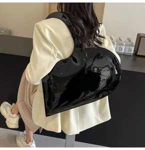 Detail of the oversized black glossy heart-shaped tote bag with a reflective mirror finish