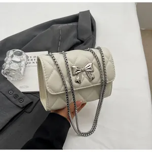 Détail du sac à bandoulière matelassé avec boucle nœud argentée et bandoulière chaîne
