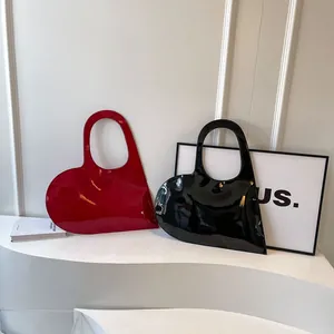 Glossy heart-shaped tote bags in red and black colors with a minimalist fashion style