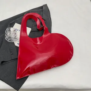 Glossy red heart-shaped patent leather handbag for women in a stylish modern design