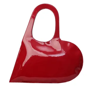 Glossy red heart-shaped handbag with a stylish asymmetric silhouette and top handle