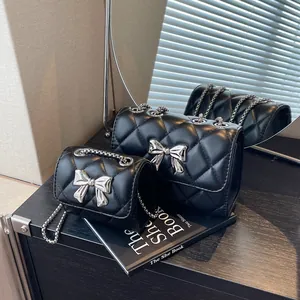 Sac à bandoulière matelassé noir avec nœud en métal argenté et motif de losanges
