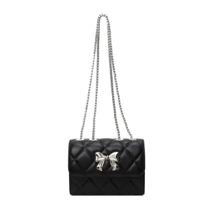Sac bandoulière noir matelassé avec nœud argenté et chaîne en métal élégante
