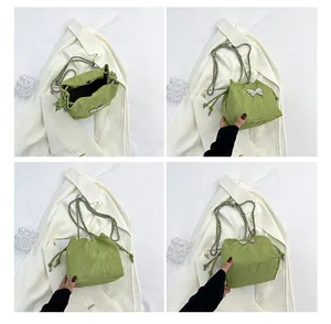 Détails du sac seau vert à texture plissée avec breloque papillon et chaîne argentée