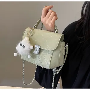 Détail du sac en cuir vert clair avec texture marbre, surpiqûres et fermoir argenté