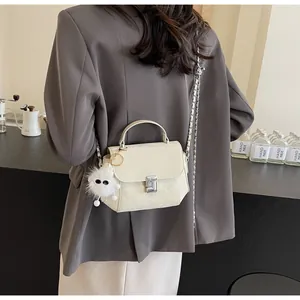 Détail du sac matelassé blanc cassé avec pendentif en peluche et fermoir en métal