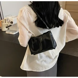 Gros plan du sac nuage plissé noir avec boucle métallique argentée sur la bandoulière