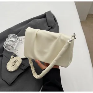 Détail du sac carré plissé crème avec texture souple et doubles bandoulières