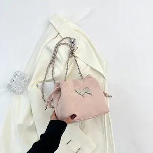 Sac seau rose à cordon avec chaîne papillon argentée et texture plissée