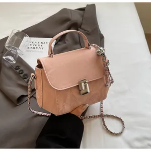 Gros plan sur le sac rose matelassé avec breloque boule argentée et fermoir pivotant