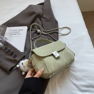 Sac à main matelassé vert olive avec chaîne argentée et charm de monstre en peluche