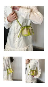 Détail du mini sac seau en paille avec bordure en cuir vert néon et texture tressée