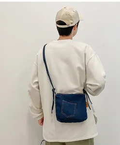 Detail view of a retro denim bucket bag featuring vintage stitching and decorative pocket