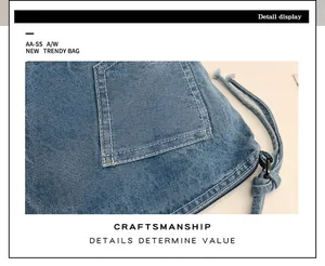 Detailed view of blue denim bucket bag with white contrast stitching and metal zipper
