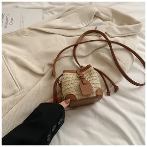 Détail du mini sac seau en paille avec bordure en cuir marron et cordon serrage