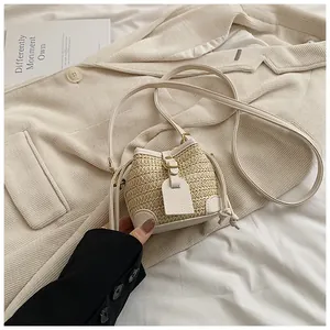 Détail du mini sac seau en paille tissée avec cordon en cuir et finition texturée