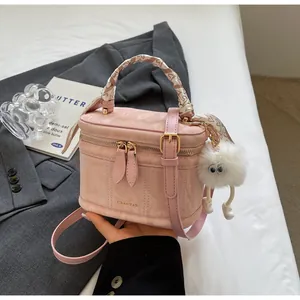 Detail of pink marble bucket bag with silk-wrapped handle and furry monster charm