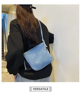 Detailed back view of a blue denim bucket bag with knotted shoulder strap and pocket