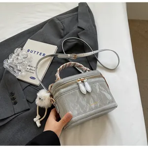 Detail of grey wrinkled leather mini bucket bag with silk scarf handle and plush charm