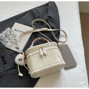 Detail of marble-patterned bucket bag featuring silk-wrapped handle and plush charm