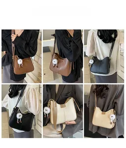 Vues détaillées du sac à bandoulière en marron, noir et beige avec pendentif en peluche