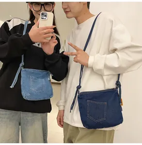 Detail of blue denim bucket bag featuring jeans pocket design and adjustable rope strap