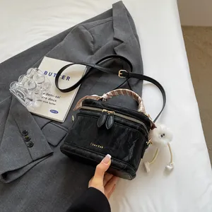 Elegant black marble-patterned bucket bag with silk scarf handle and plush charm
