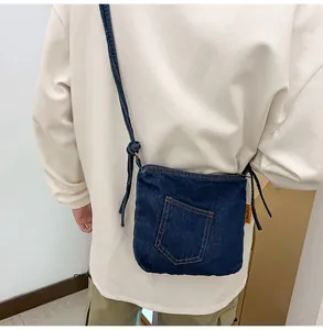 Close-up of dark blue denim bucket bag with vintage stitching and orange side label detail