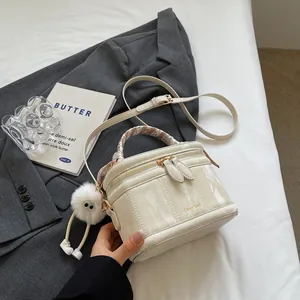 Fashionable marble texture bucket bag with silk handle and plush charm on grey blazer