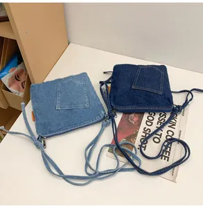 Detail view of denim bucket bag with vintage patchwork and zipper on natural fabric texture