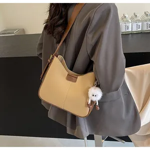 Détail du sac cabas bicolore kaki et marron avec un joli pendentif monstre en peluche