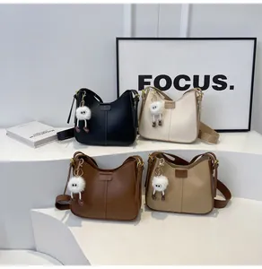 Détails de quatre sacs à bandoulière demi-lune en noir, beige, marron et kaki avec charmes doux