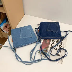 Vintage denim patchwork bucket crossbody bag in dark and light blue with orange label
