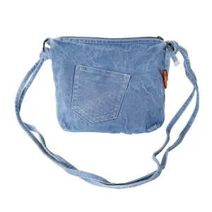 Light blue washed denim crossbody bucket bag with orange tag and front pocket detail