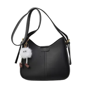 Sac à bandoulière minimaliste noir en similicuir avec un porte-clé pompon dessin animé