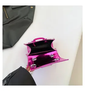 Détail du mini sac en cuir verni fuchsia avec fermeture magnétique et doublure noire
