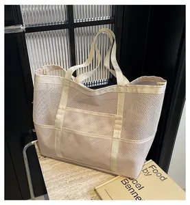 Detalle de bolso tote de malla crema con tejido transpirable y asas de lona reforzadas