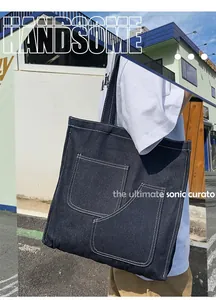 Outdoor shot showing a large denim tote bag with contrast stitching and two front pockets