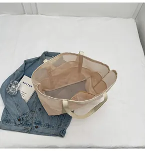 Detalle interior de la bolsa de malla beige con bolsillos organizadores y textura