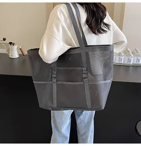Vista posterior de una modelo con un bolso tote grande de malla gris reforzada