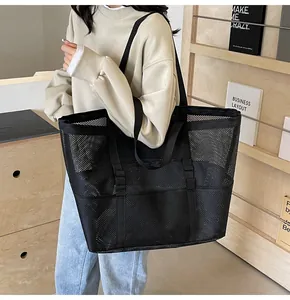 Detalle de bolsa tote de malla negra de gran capacidad con asas dobles de cincha fuerte